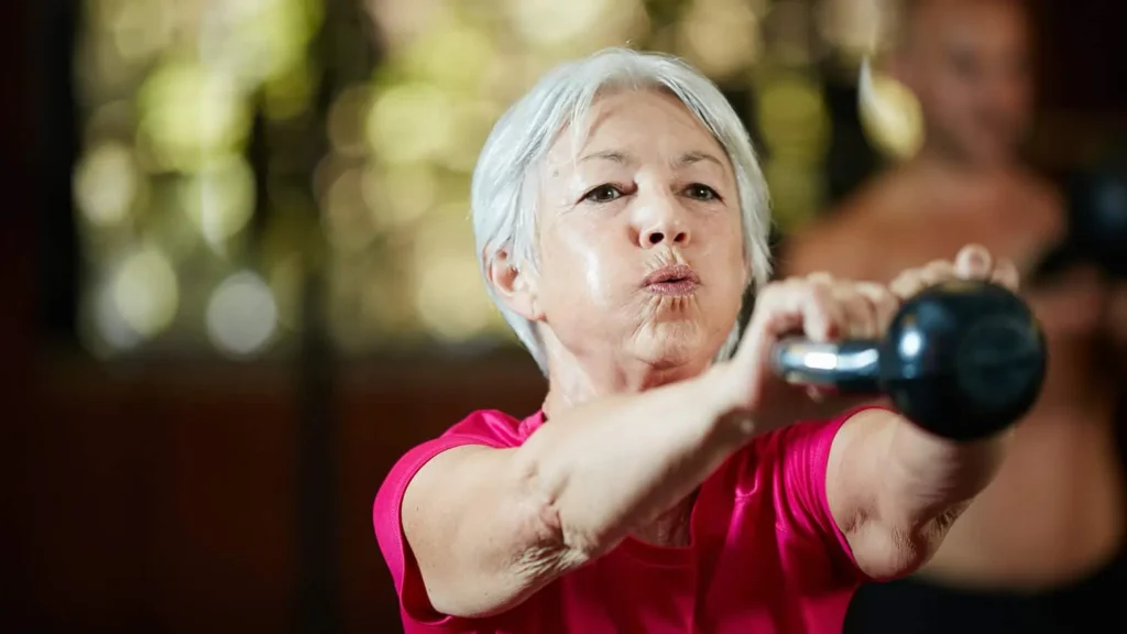 Toning Arms Without the Bulk: Is It Achievable? 1 Woman doing resistance band exercises for toned arms Woodley